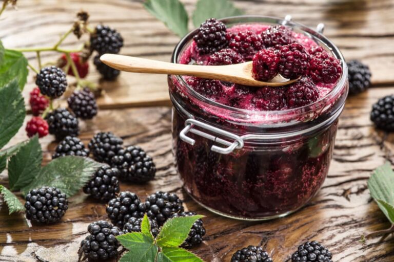 borcan cu dulceata de mure alaturi de mure proaspete pe masa rustica