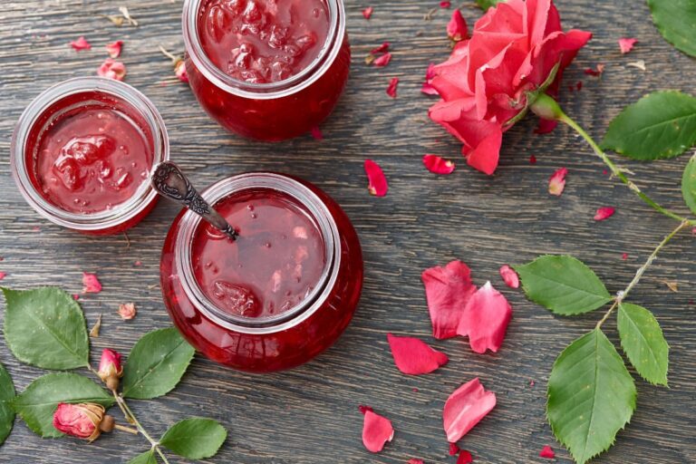 borcane cu dulceata de trandafiri pe masa rustica cu petale de trandafir