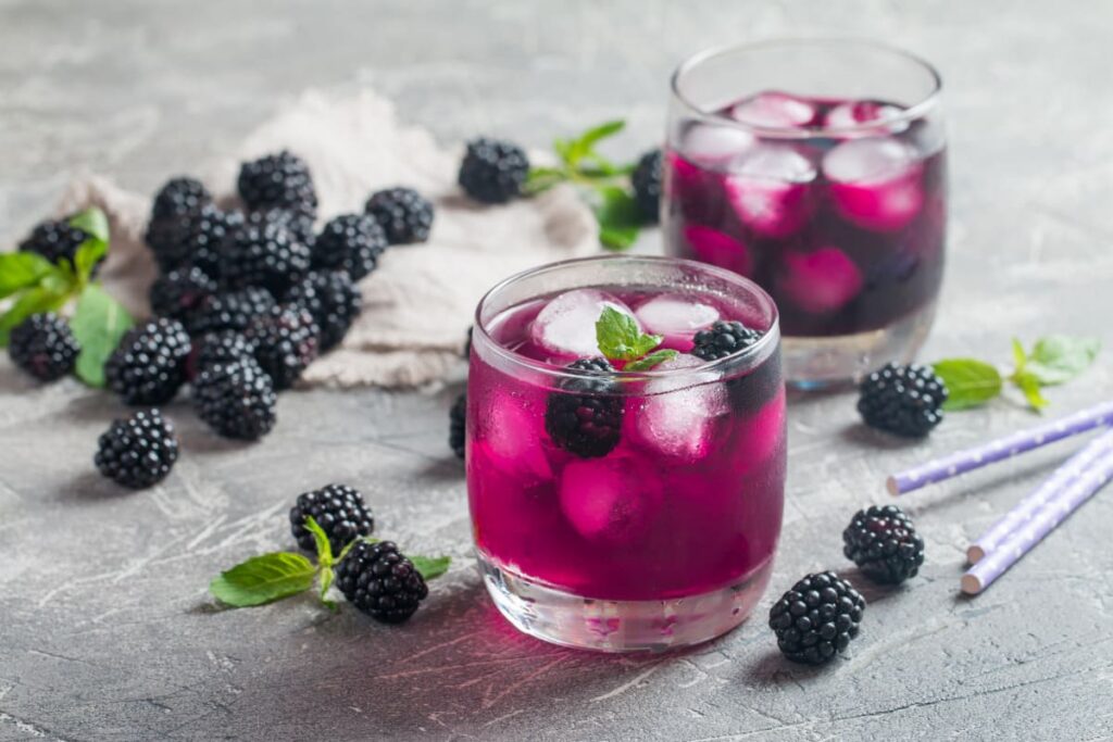 pahare cu limonada cu sirop de mure si mure proaspete pe masa