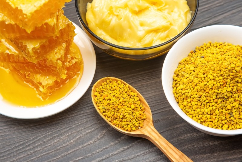 Propolis in lingura si fagure de miere pe farfurie
